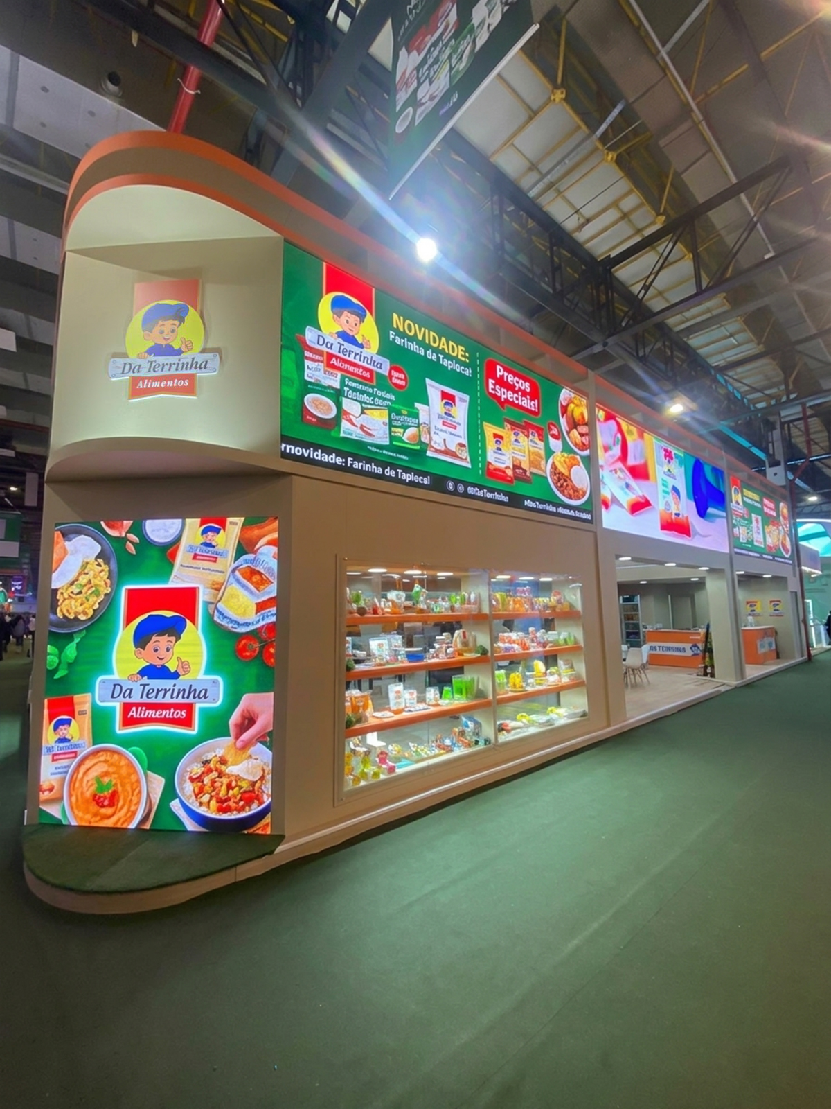 Stand da Da Terrinha Alimentos com vitrines de produtos e painéis iluminados montado pela Central Eventos