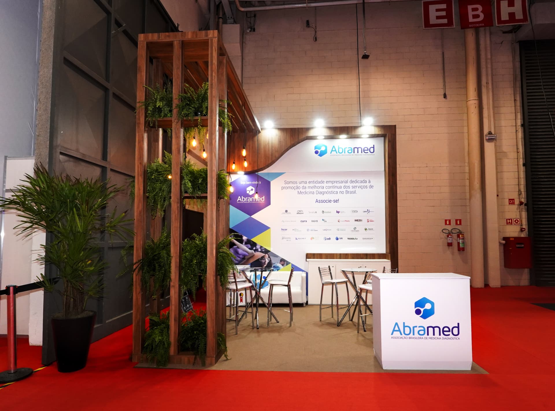 Stand da Abramed com estrutura em madeira e jardim vertical montado pela Central Eventos